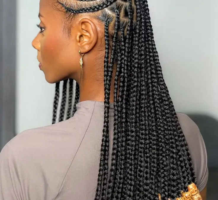 Side view of black cornrow braids finished with patterned clay beads at the ends