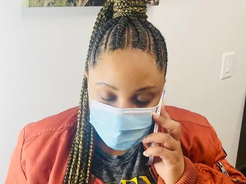 Cornrows swept back into a braided ponytail with gold highlights
