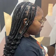 Cornrows flowing into a long curly braided ponytail