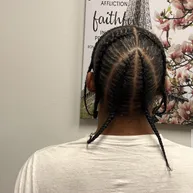 Cornrows converging into two braided ponytails