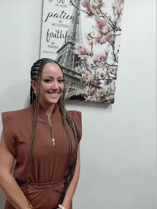 Zara wearing long braids with a center part
